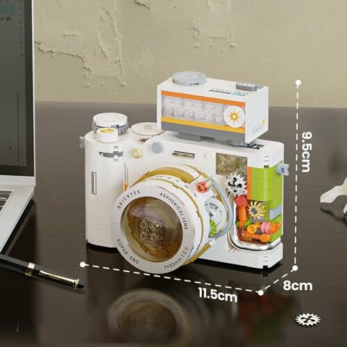 Lego Modell einer Kamera auf einem Tisch mit Maßangaben.